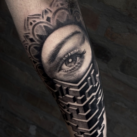 Tatuaje de ojo rodeado de mandalas y formas geométricas