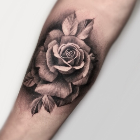 Tatuaje realista de una rosa negra y gris