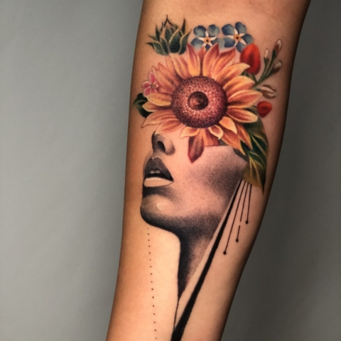 Retrato con tatuaje de girasol en el ojo y flores en la cabeza