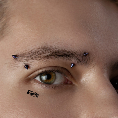2 eyebrow piercings on one eyebrow with body jewelry that has spikes