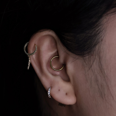 third lobe piercing with a daith piercing and a helix piercing