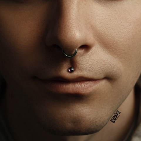 Madusa lip piercing with a moonstone cabochon end and a septum piercing with seamless ring